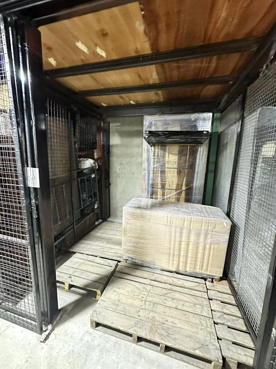 Box de guardamuebles con pallets y carga embalada en depósito seguro.