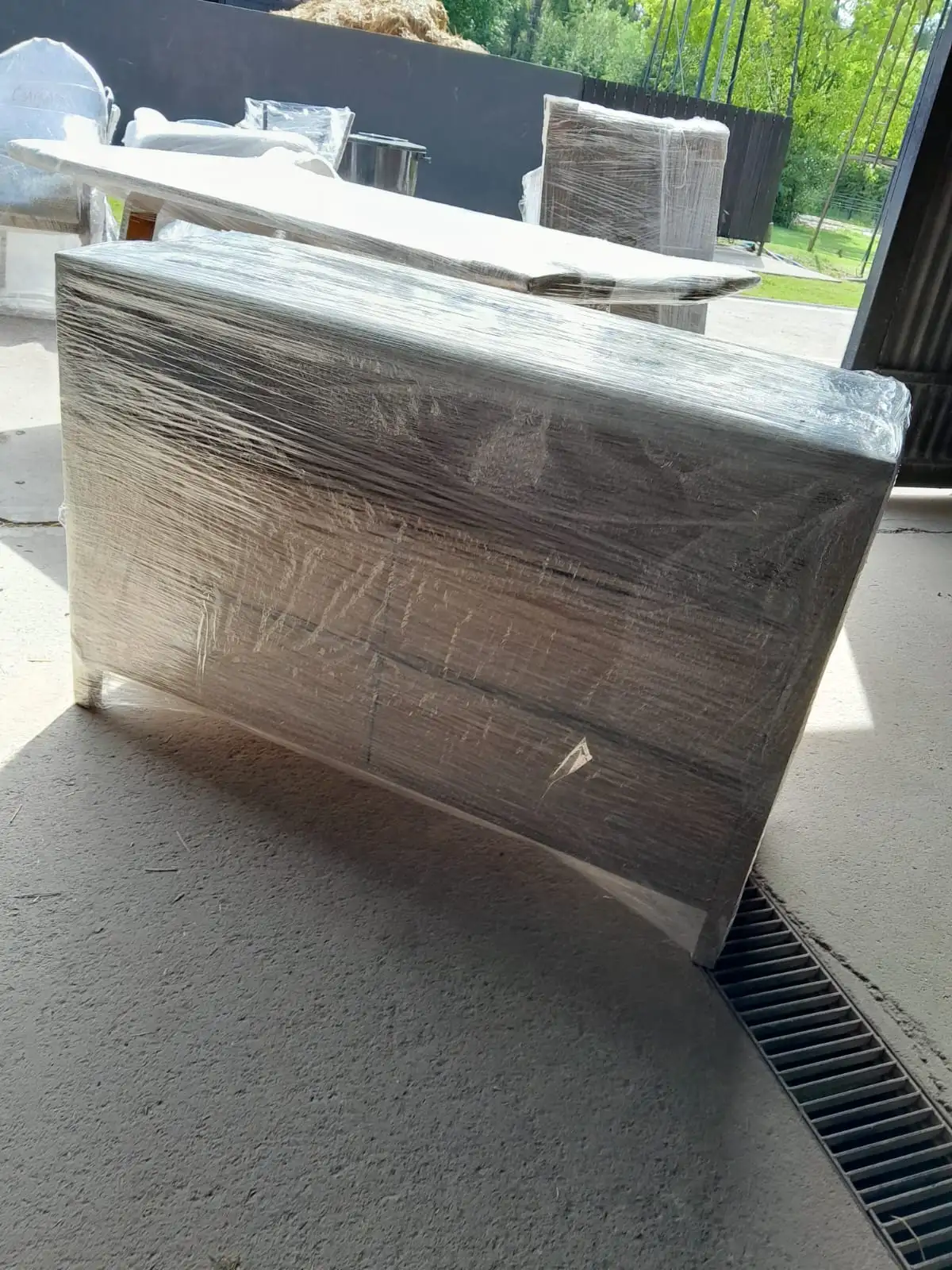 Mueble de madera envuelto herméticamente con film stretch para evitar daños en las superficies y bordes.