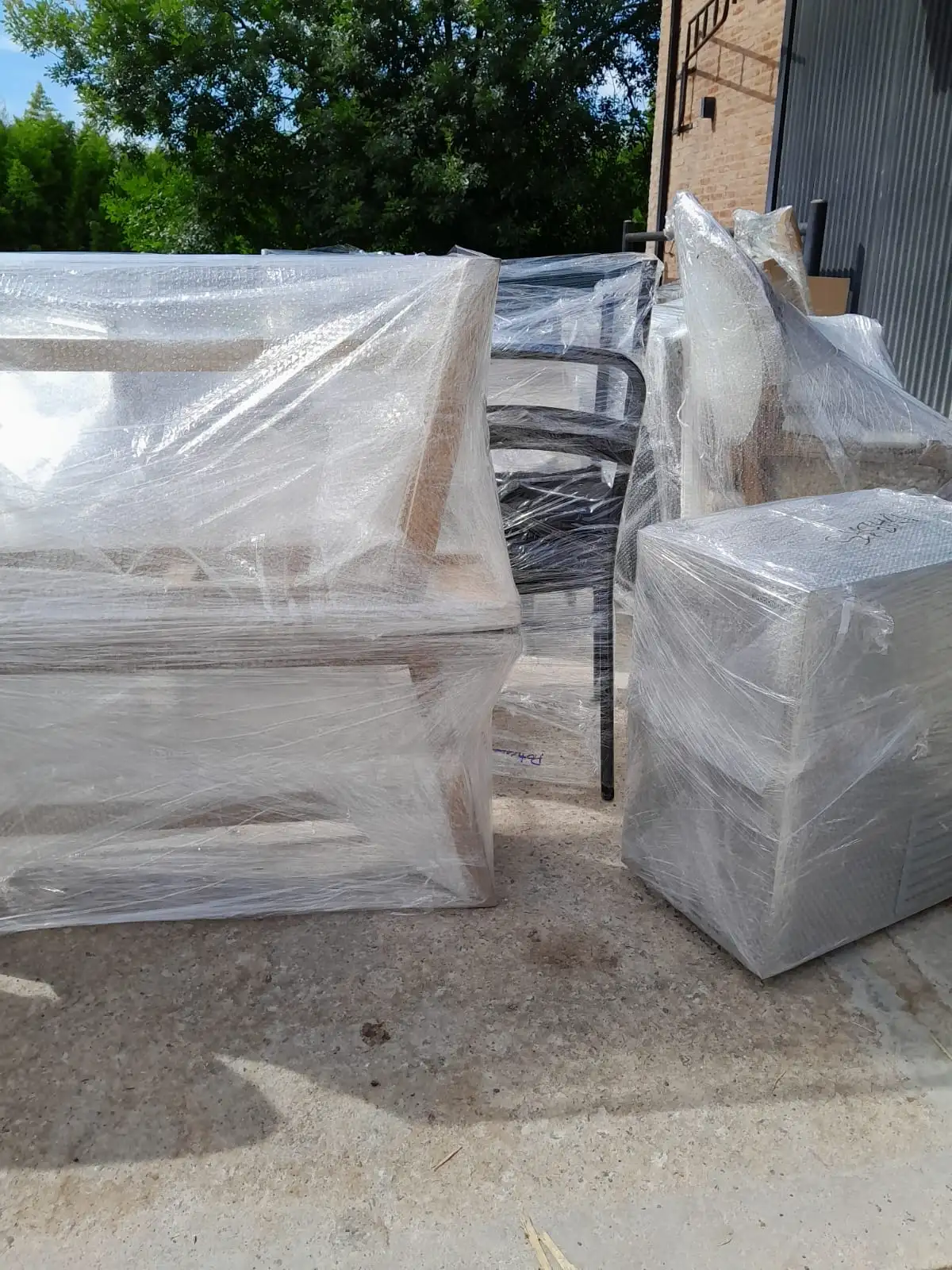 Conjunto de muebles de madera embalados individualmente y agrupados para facilitar la logística de carga.