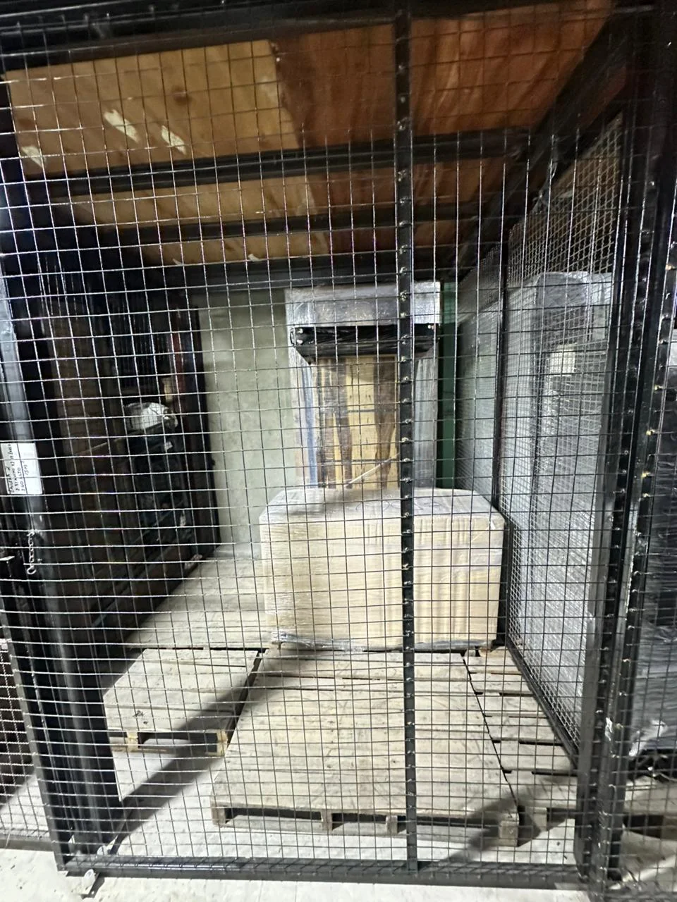 Interior de box de guardamuebles con pallets y muebles embalados.